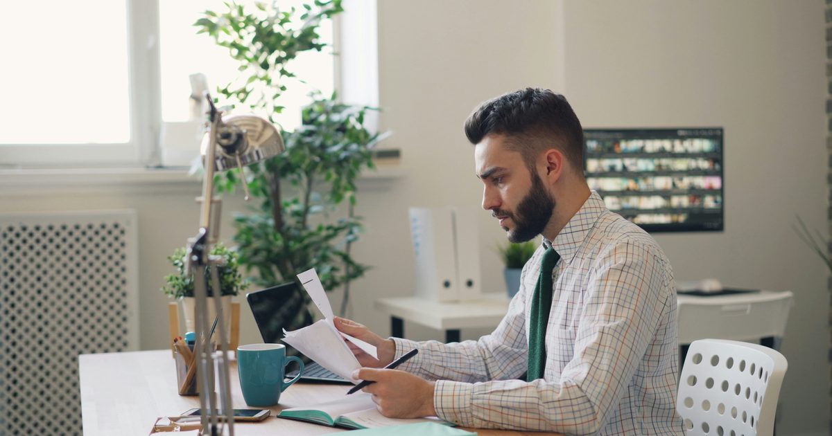 Photo : personne analysant des documents et une facture, symbole d’une hausse de mutuelle en 2026