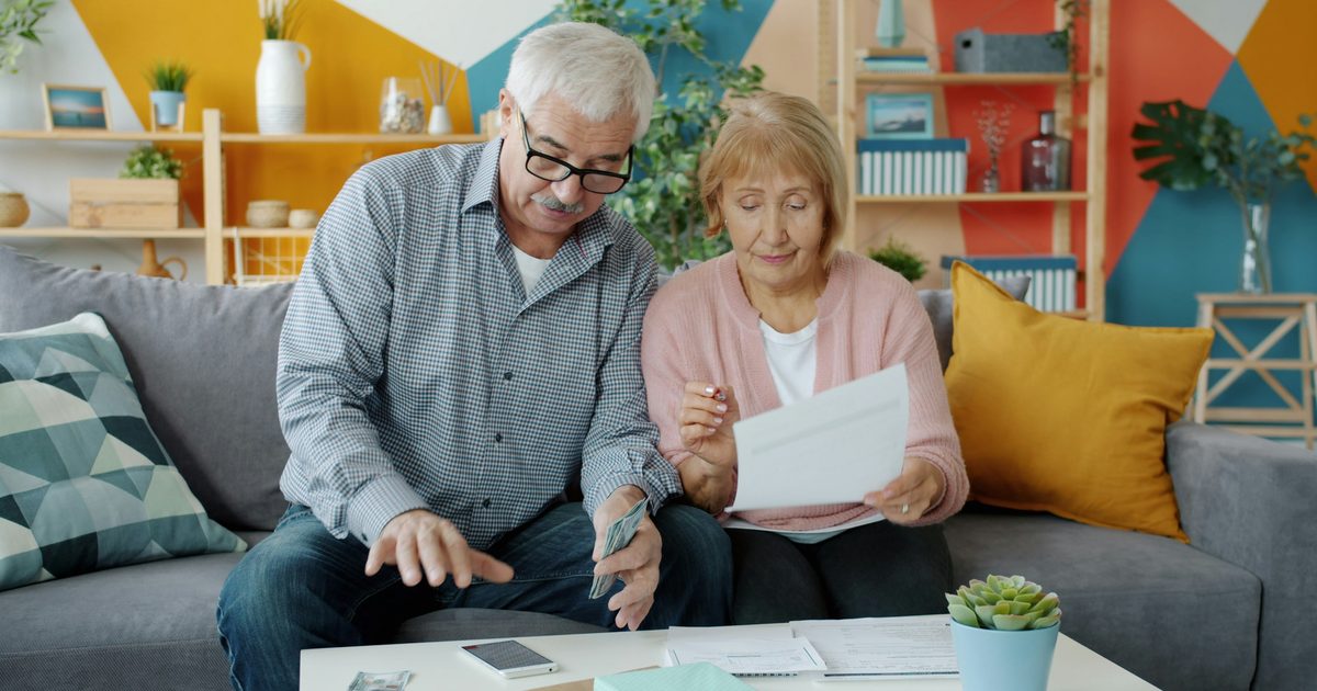 Couple de seniors examinant des documents de mutuelle